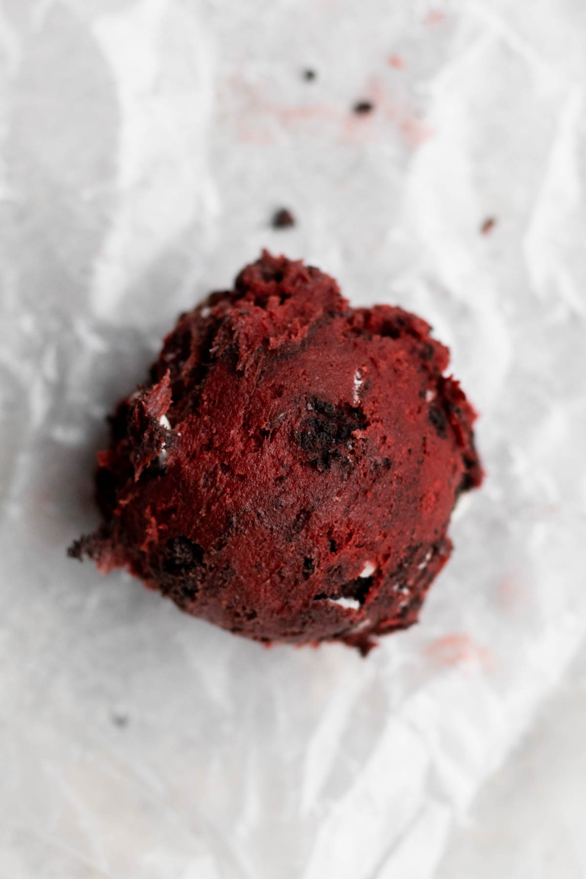 A round scooped ball of red cookie dough.