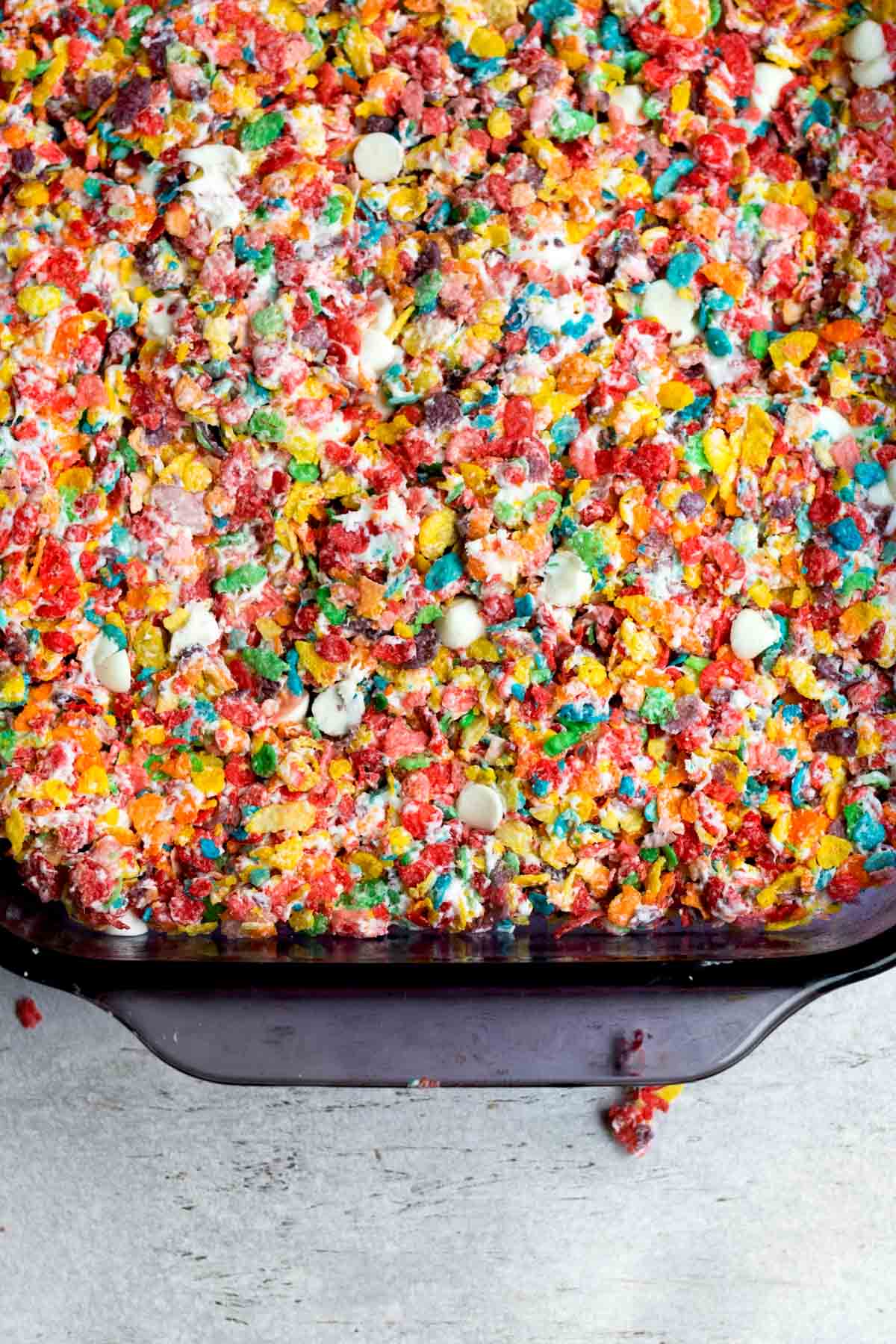 Filling a baking dish with the fruity pebbles mixture.