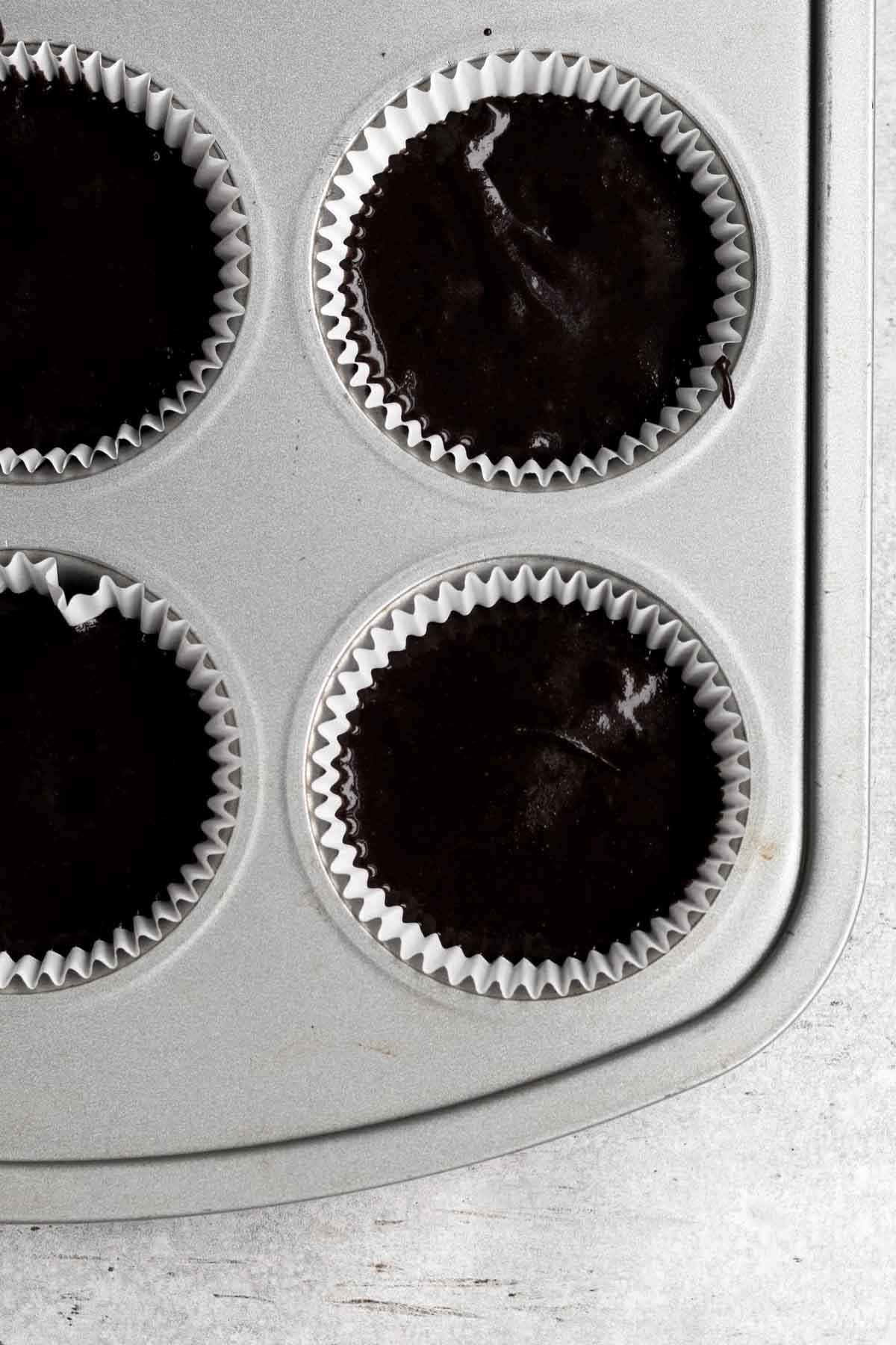 Filling cupcake tins with the chocolate batter.