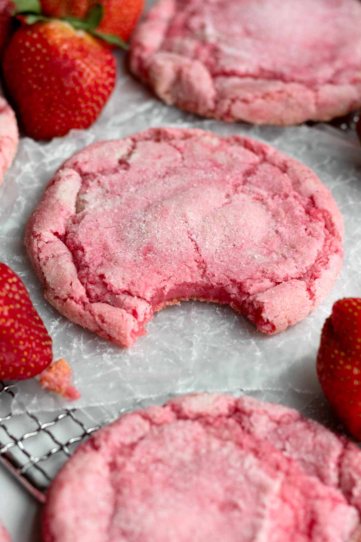 A bitten strawberry sugar cookie reveals the soft insides.