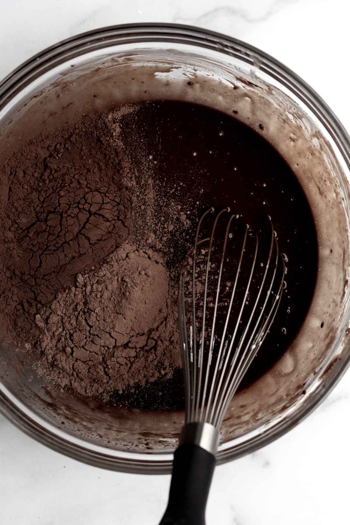 Adding in two cocoa powders with a whisk.