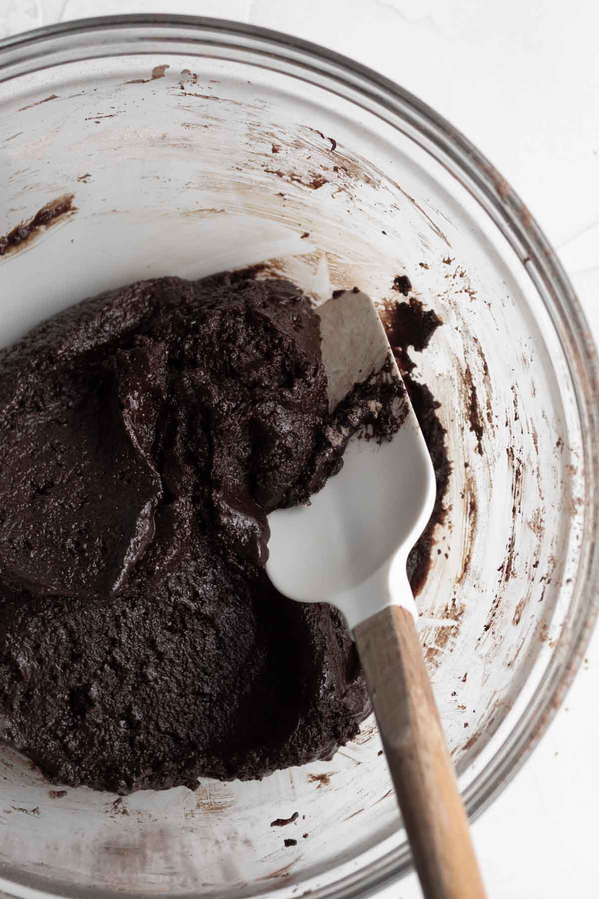 Mixing the brownie batter in a bowl with a spatula.