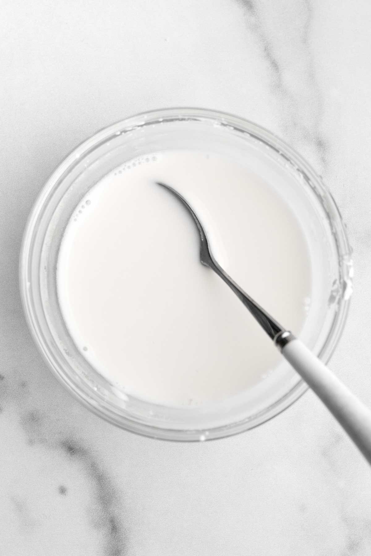 A bowl of white cornstarch water and a spoon.