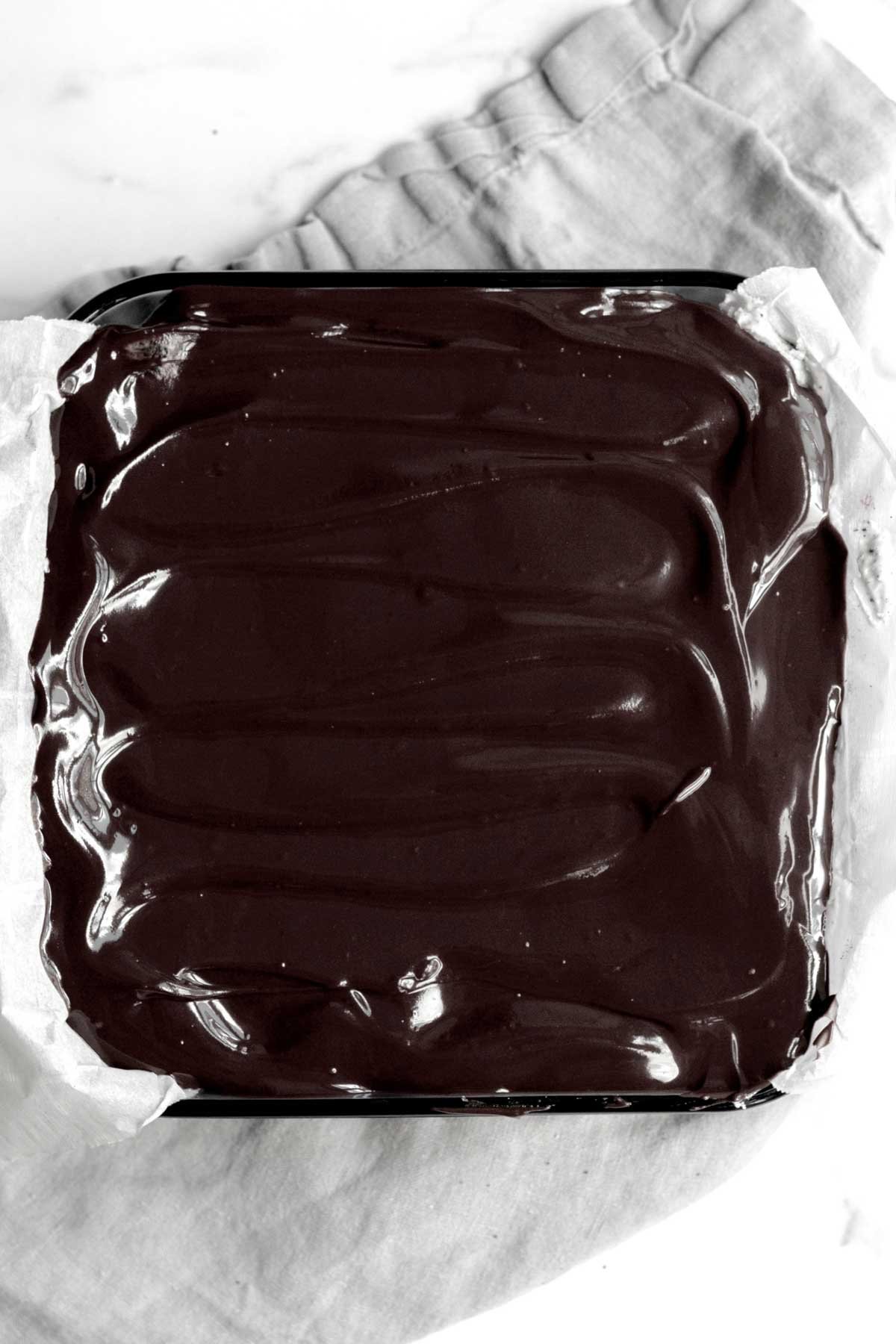 The chocolate ganache is spread evenly and smooth on top.