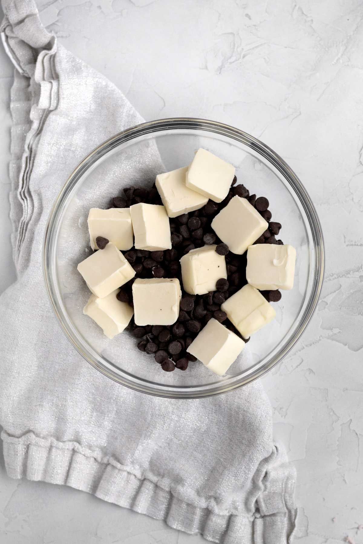 Slices of butter and chocolate chips in a bowl.