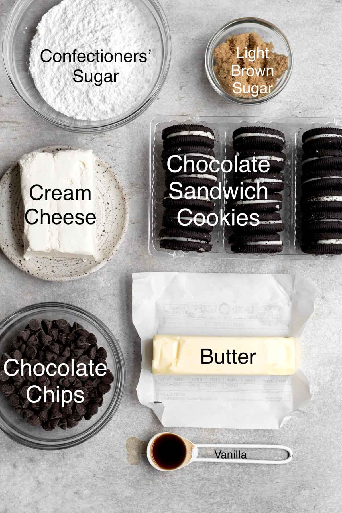 Confectioners' sugar, light brown sugar, cream cheese, chocolate sandwich cookies, chocolate chips, butter and vanilla in separate containers.