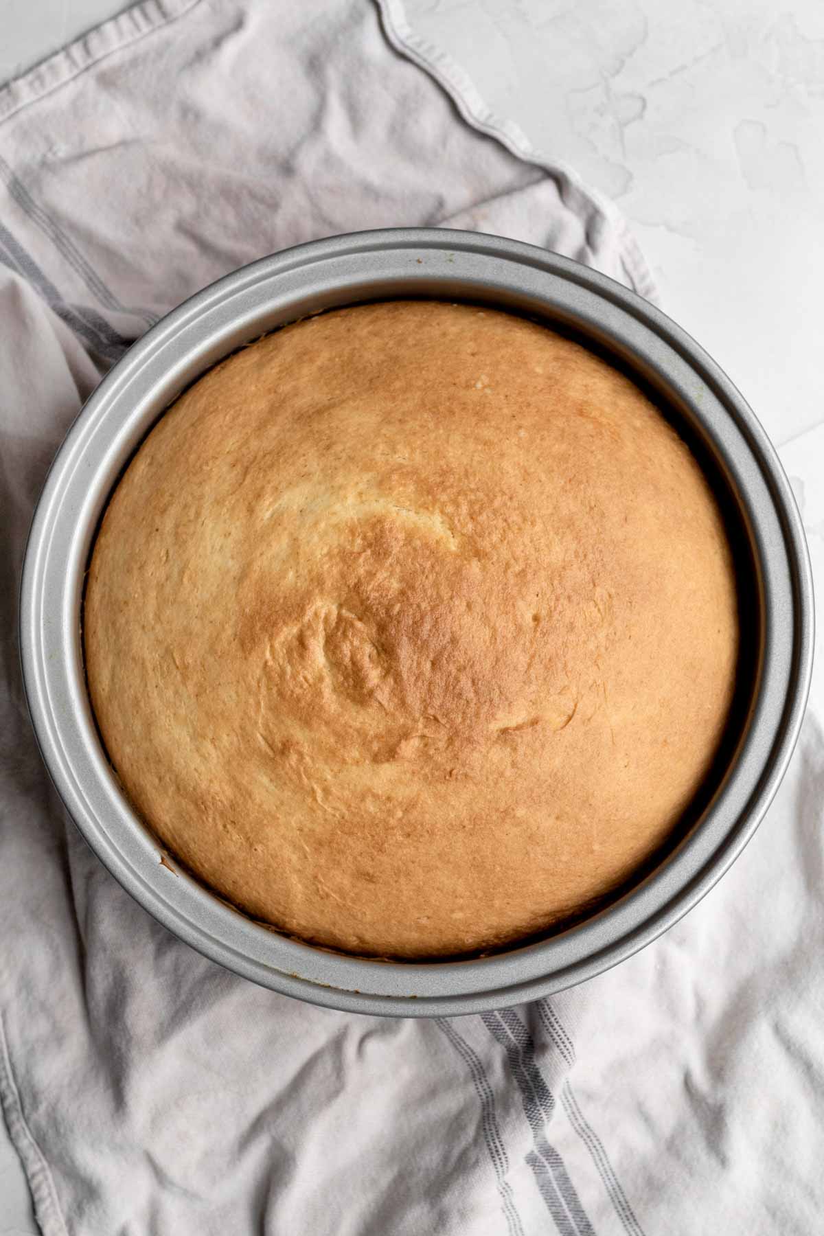 Golden brown cake in a silver cake pan.