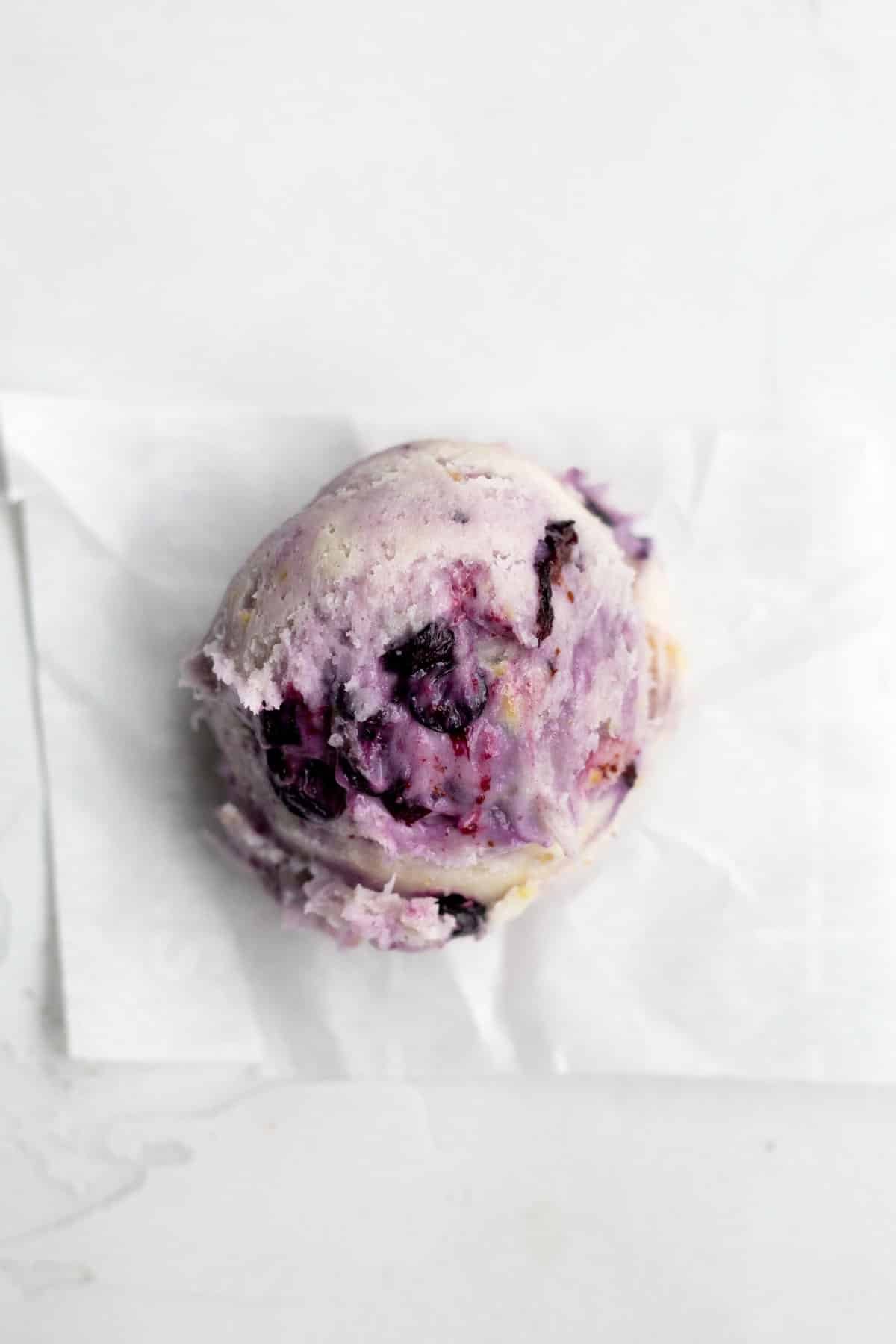 A scooped ball of cookie dough with wild blueberries.