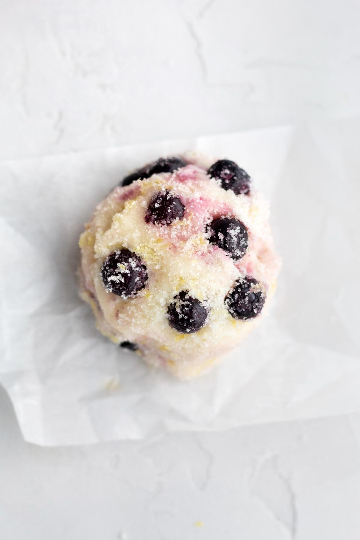 A scooped ball of Lemon Blueberry Cookies with regular blueberries.