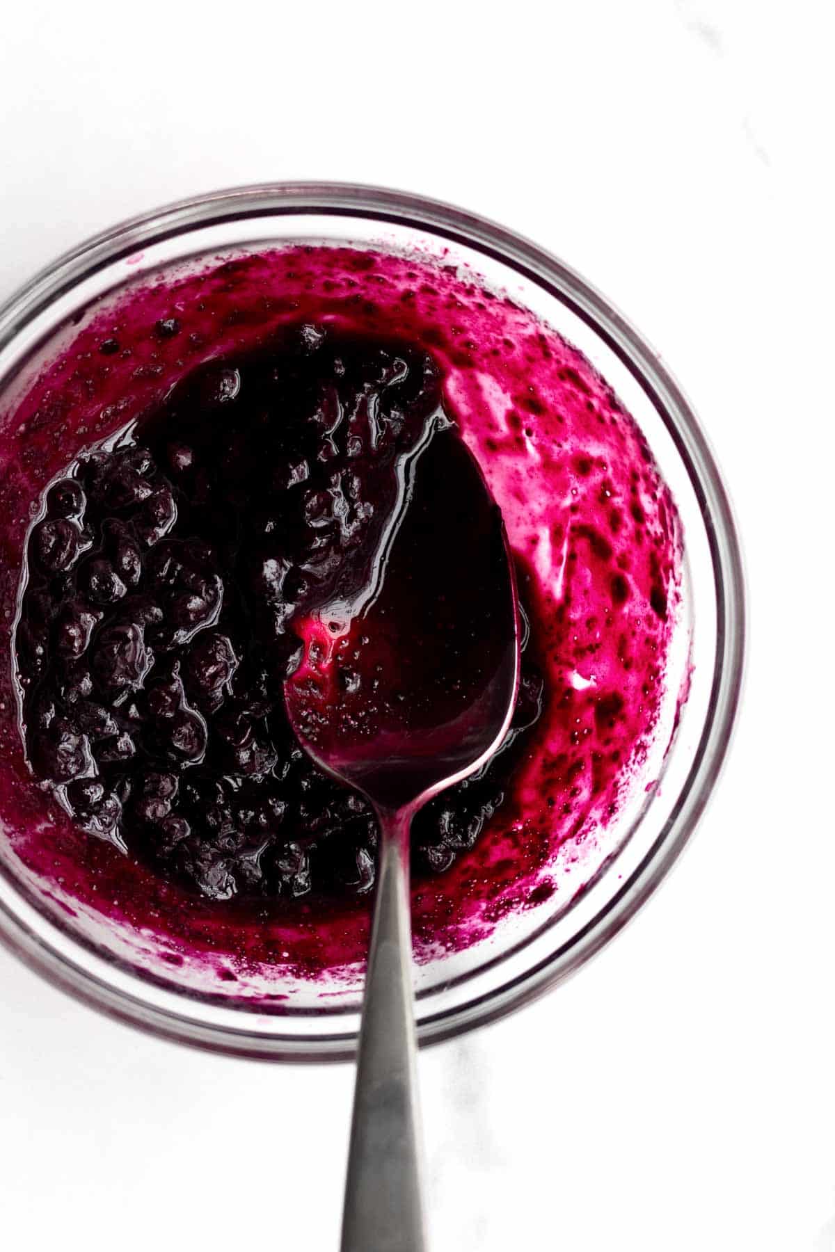 Heated blueberries stain the sides of the bowl in a magenta hue.