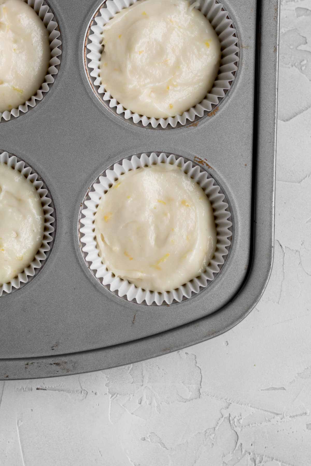 Filling a cupcake tin with wrappers and the batter.