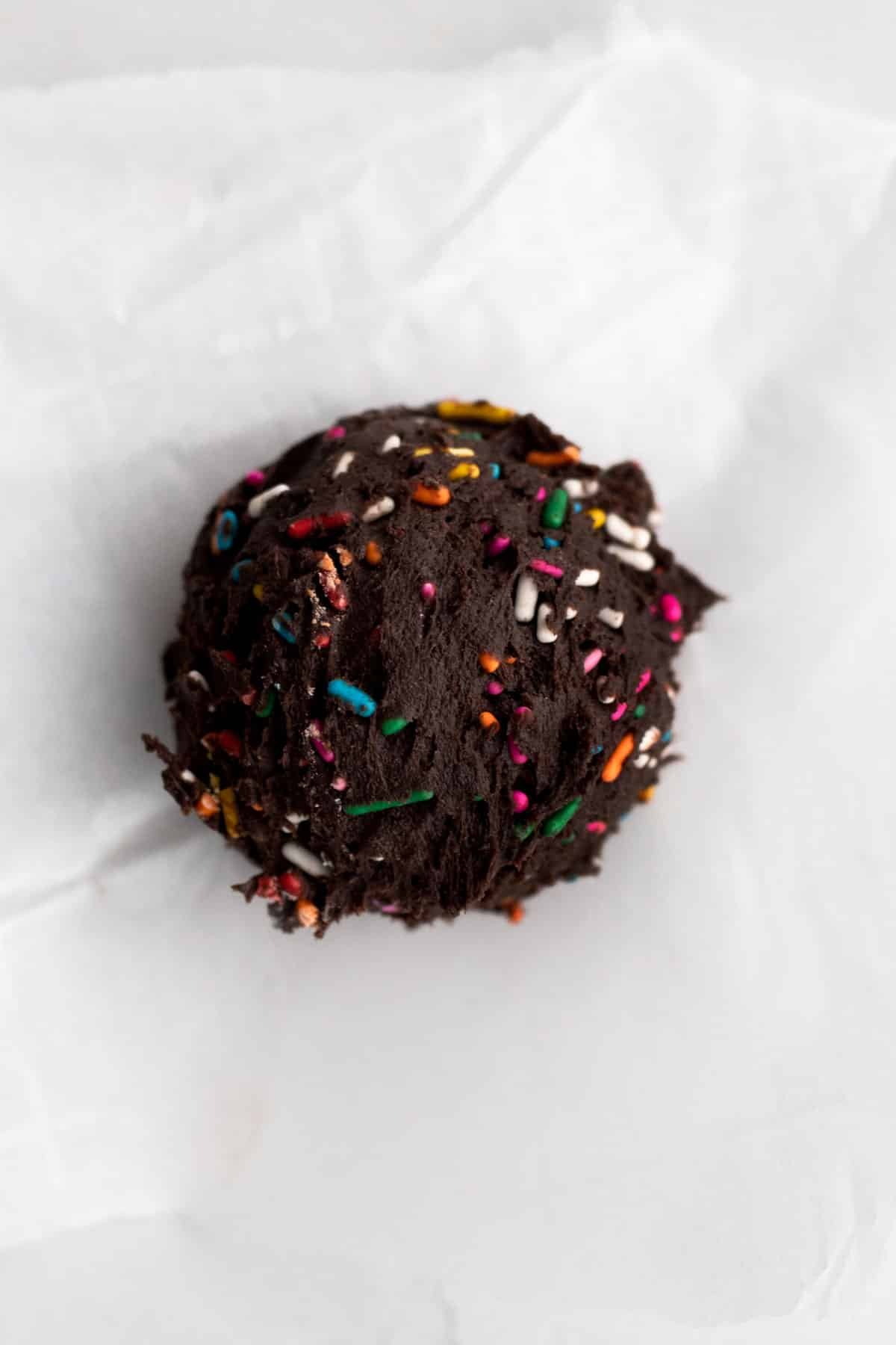 A ball of delicious chocolate cookie dough infused with rainbow sprinkles.