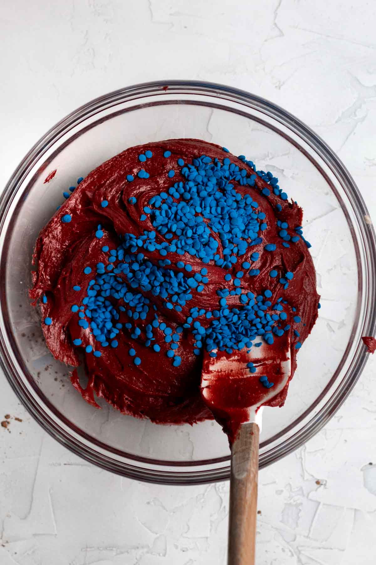Mixing in hundreds of tiny round blue sprinkles into the batter.