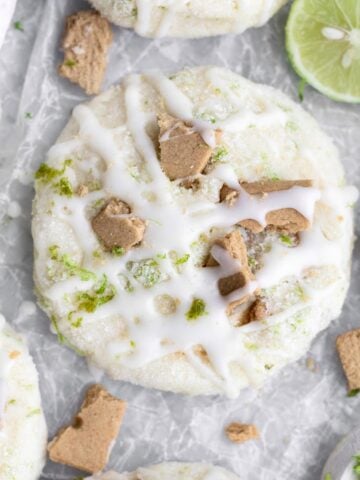Scrumptious sugar coated Key Lime Cookies adorned with graham cracker shards and sweet cream cheese glaze.