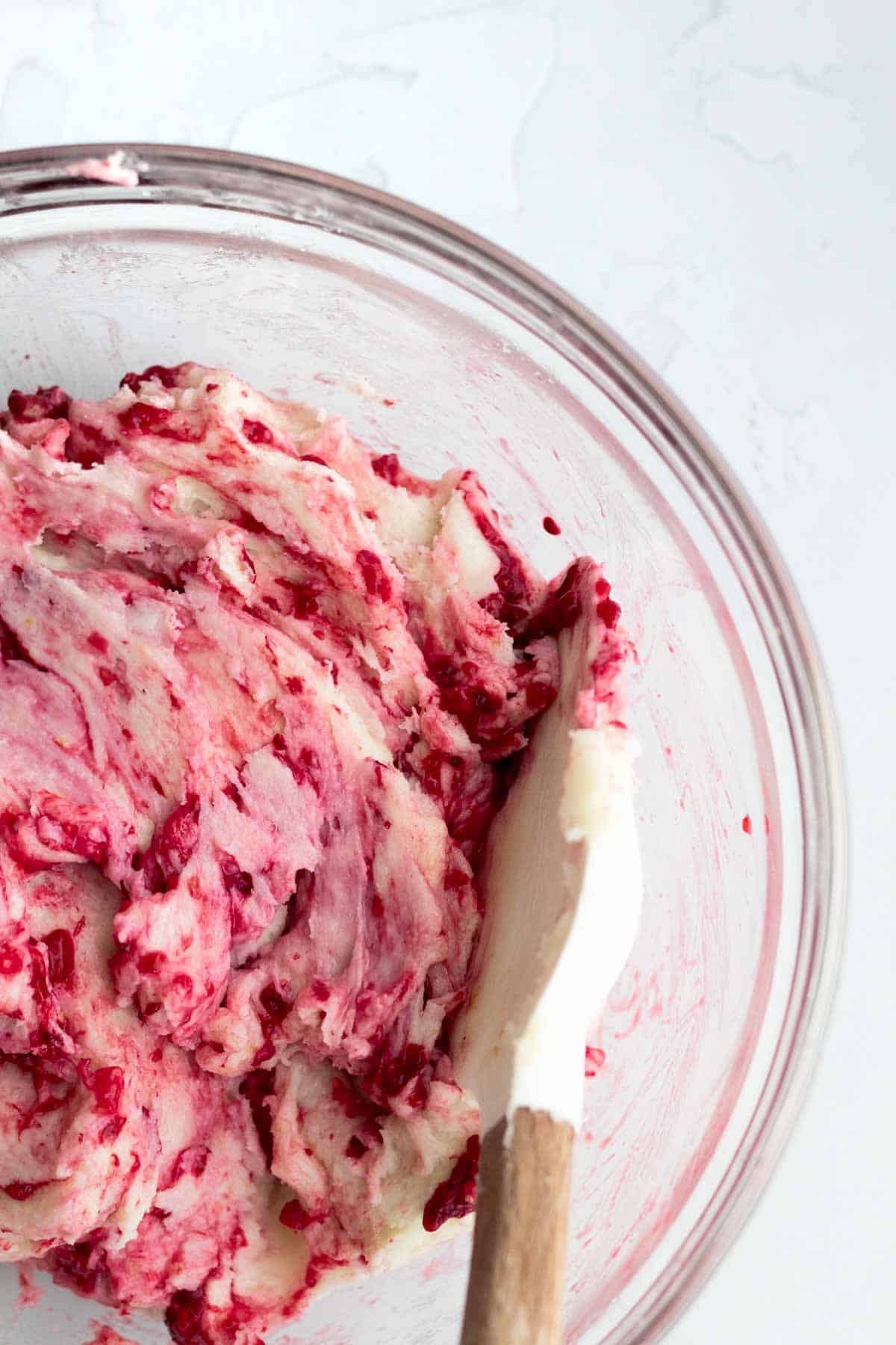 Adding the frozen raspberries into the batter.