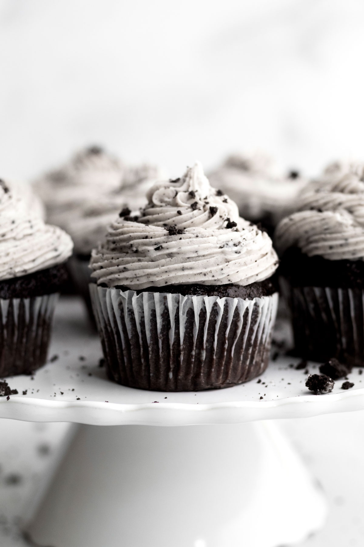 Topping the vanilla filled baked cupcake with a perfect swirl of cookies and cream frosting.