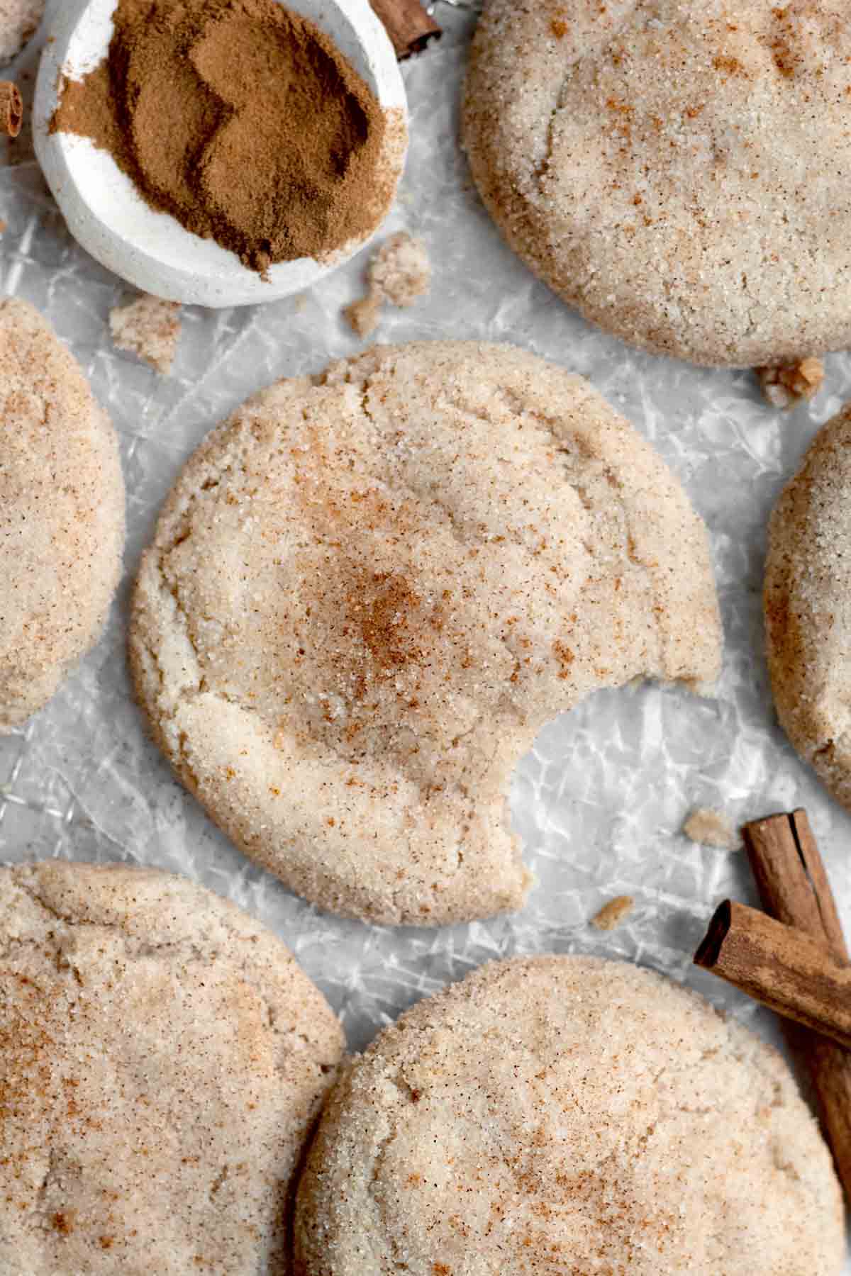 A delicious Gluten Free Snickerdoodle covered in cinnamon sugar with a bite taken out.