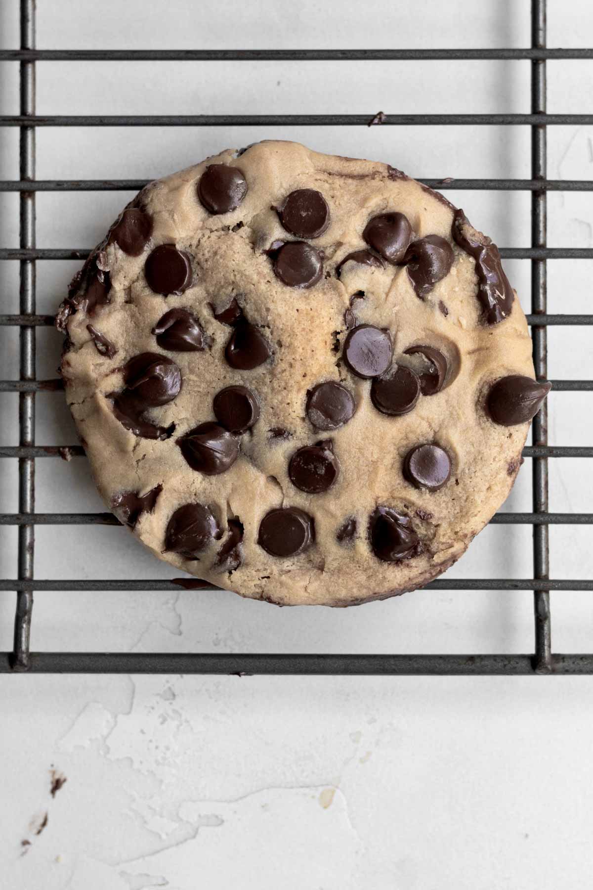 A fresh Microwave Chocolate Chip Cookie on a cooling rack.
