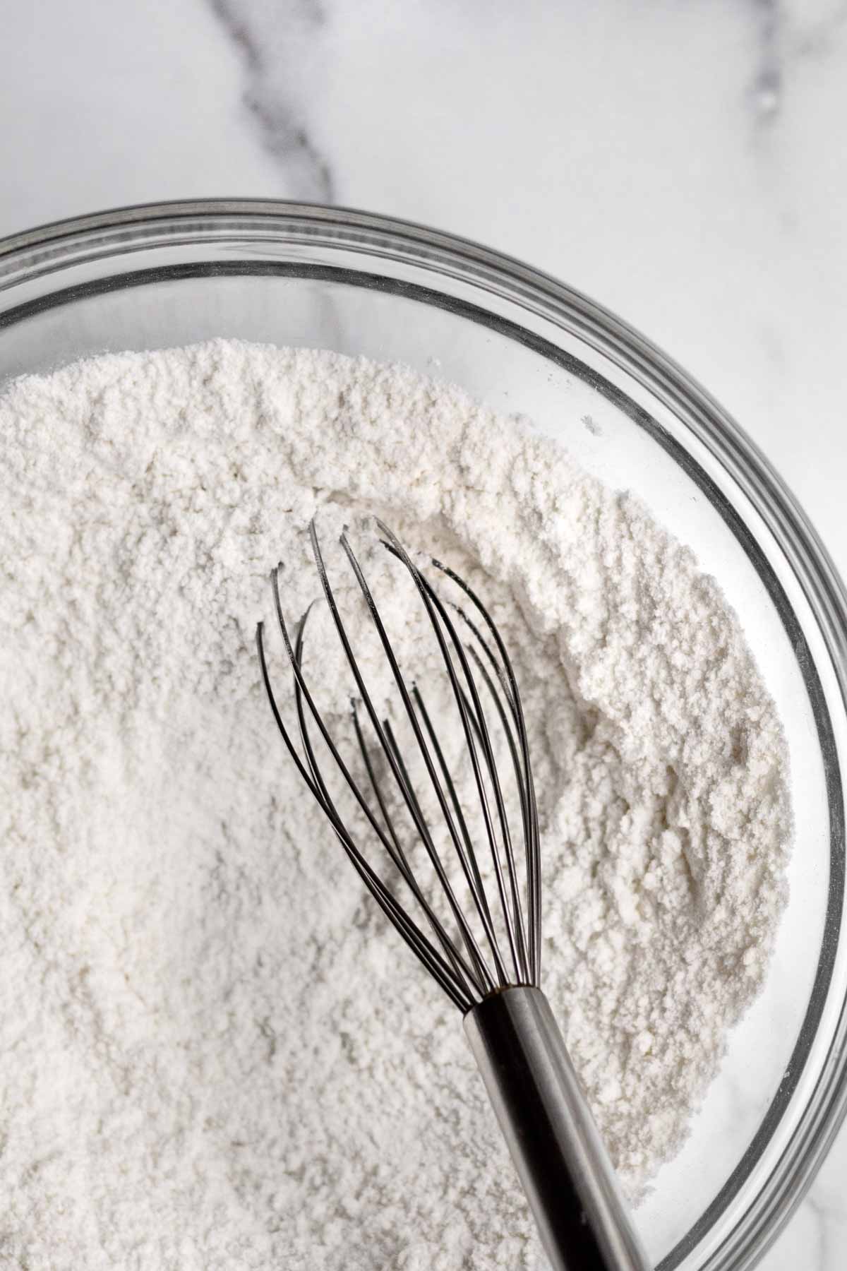 A whisk with the white dry ingredients.