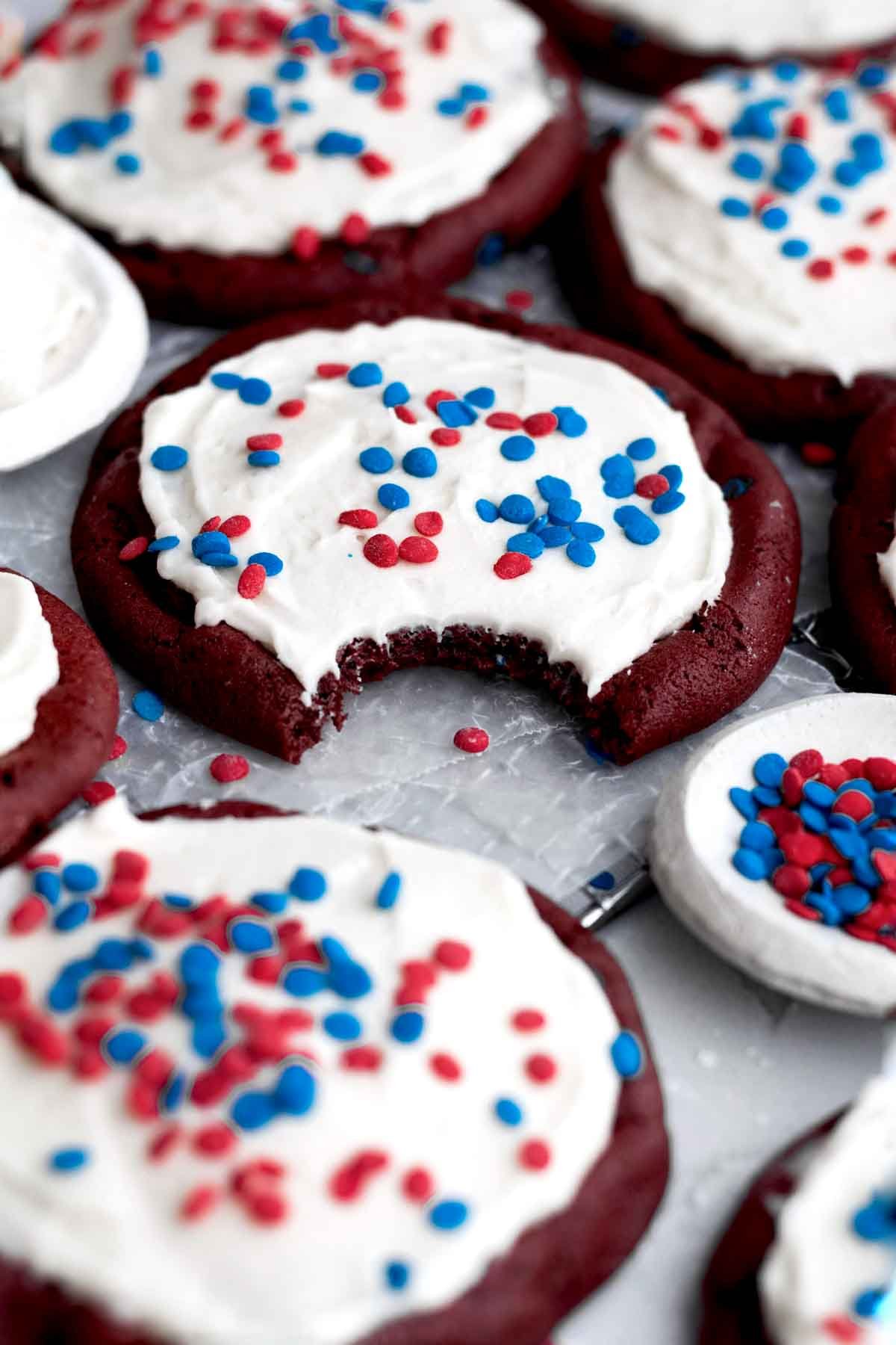Red velvet cookies with delicious cream cheese frosting topped with red and blue sprinkles.
