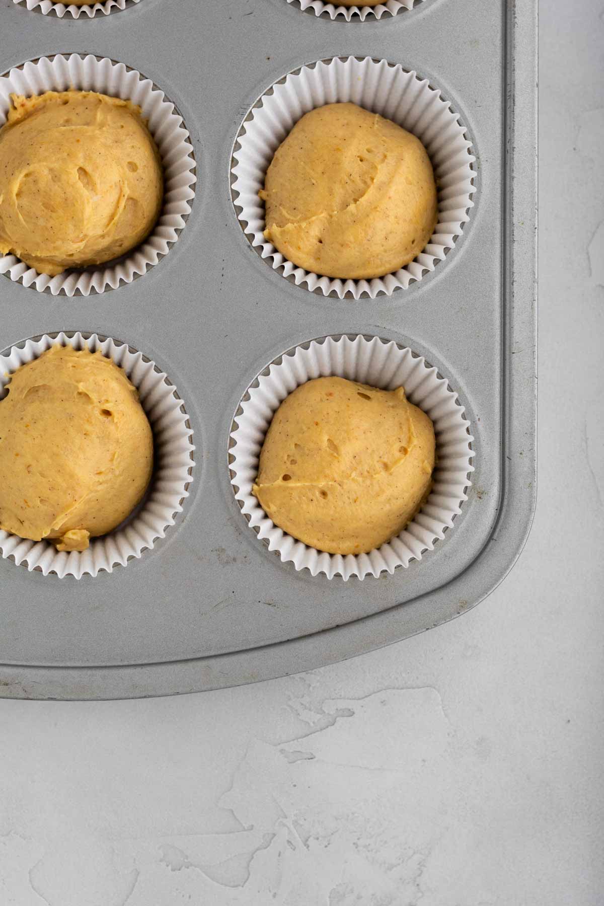Filling cupcake tins with the batter.