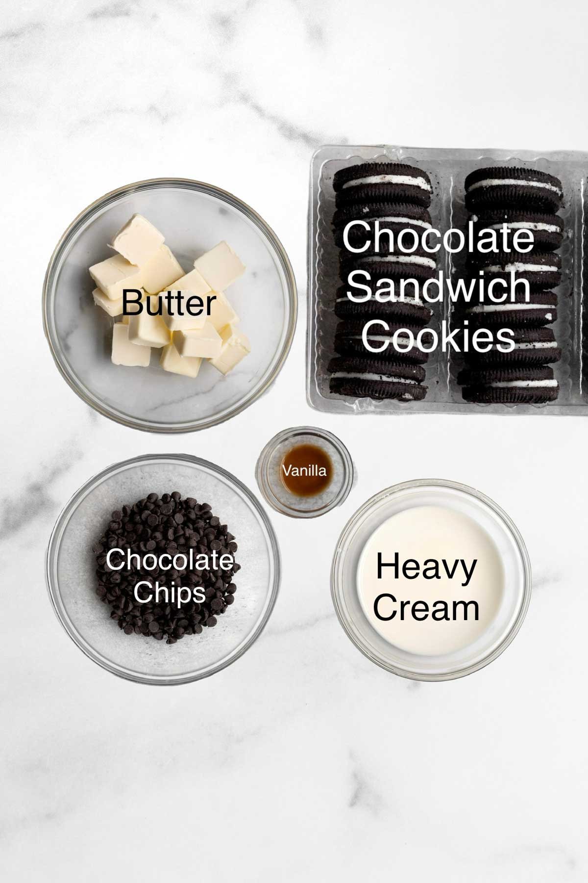 Butter, chocolate sandwich cookies, chocolate chips, vanilla and heavy cream in separate containers.