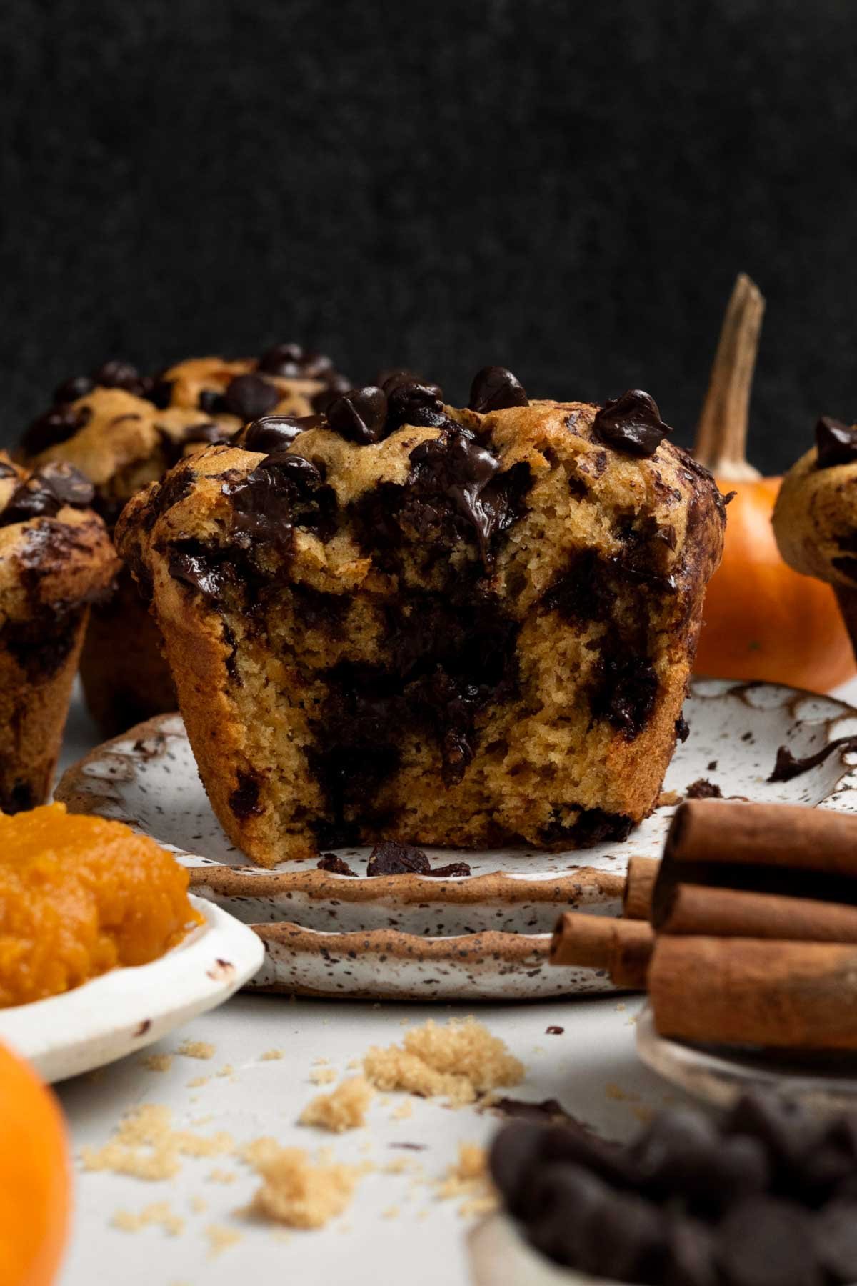 A halved Gluten Free Pumpkin Muffin with melted chocolate chips cascading down the warm soft insides.