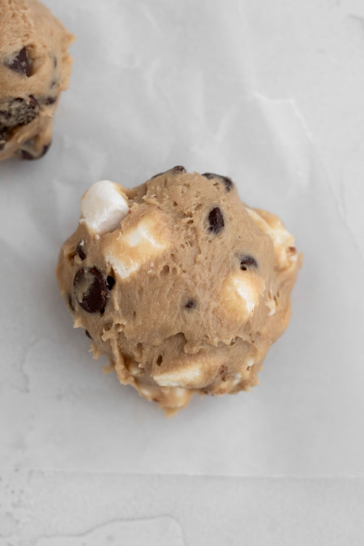 A scooped ball of chocolate chip marshmallow cookie dough,