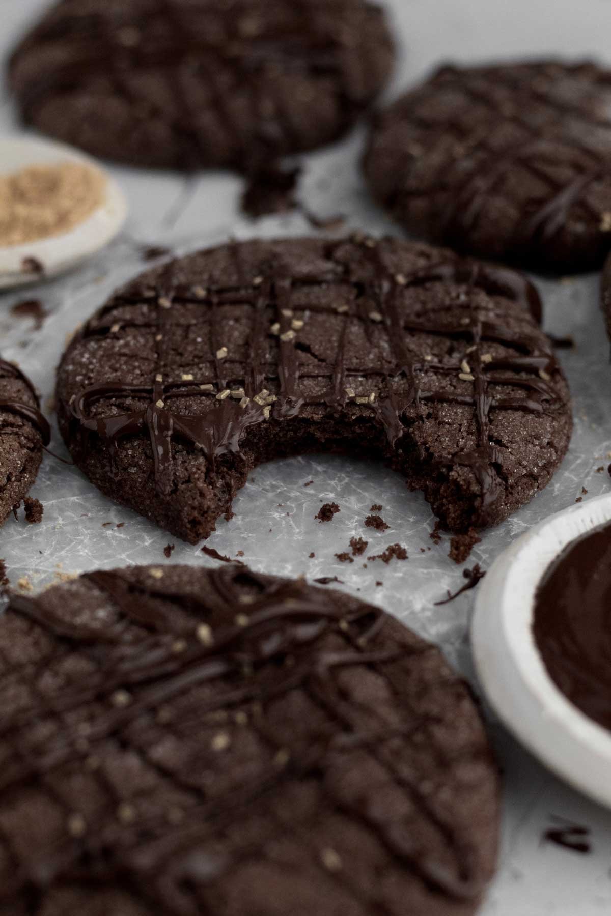 A bite taken from the soft delicious Chocolate Ginger Cookie reveals spiced and rich baked perfection.