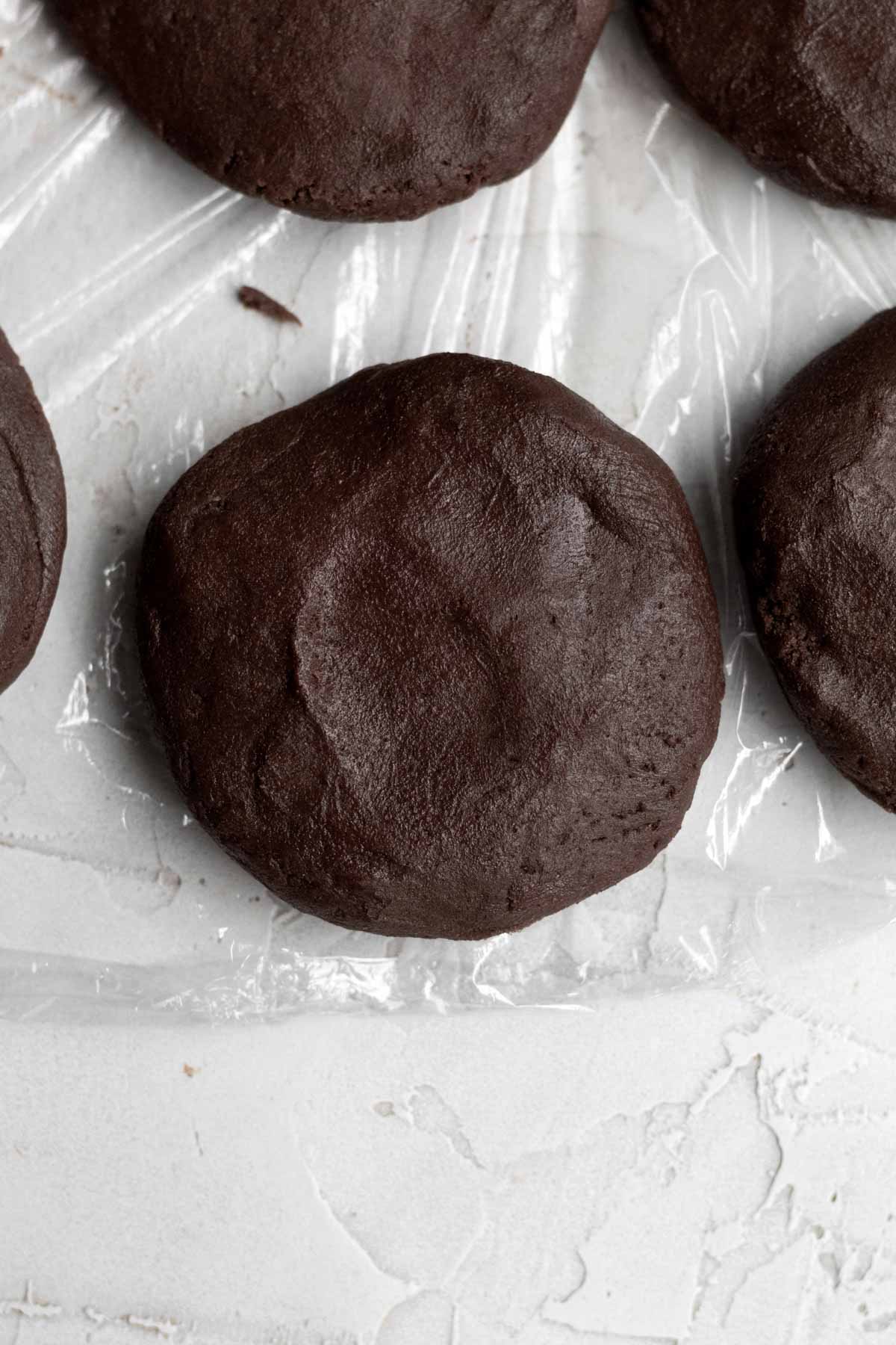 Flattening the dough ball into a small cookie shaped disc.