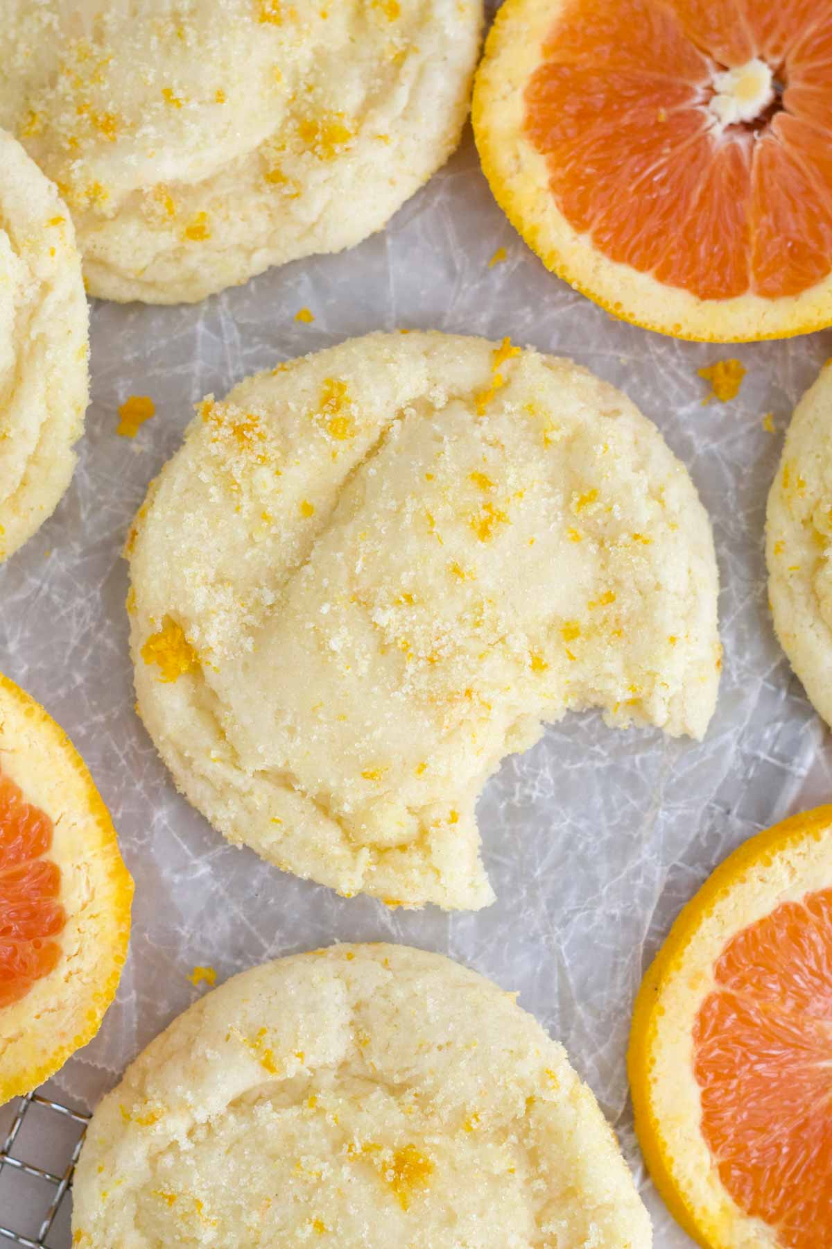 An sugary Orange Cookie with a bite taken, ready to be finished.