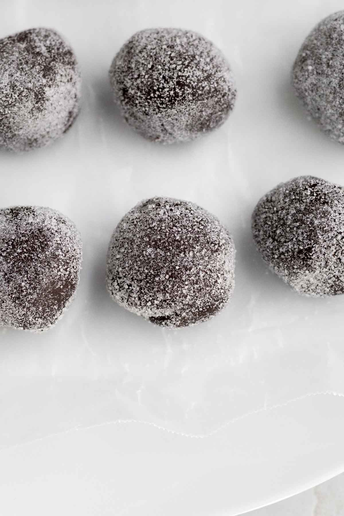 Cookie dough balls coated in granulated sugar.