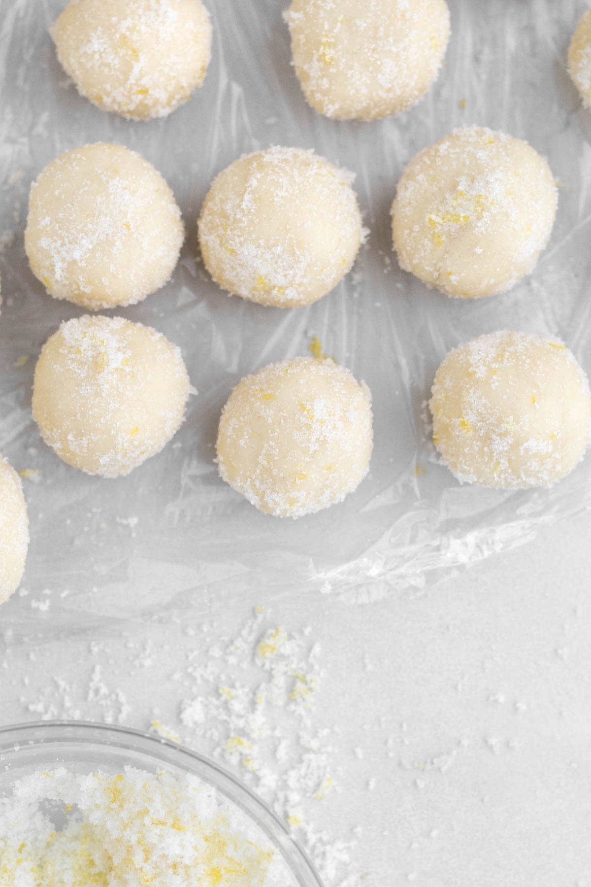 Cookie dough balls covered in granulated sugar.