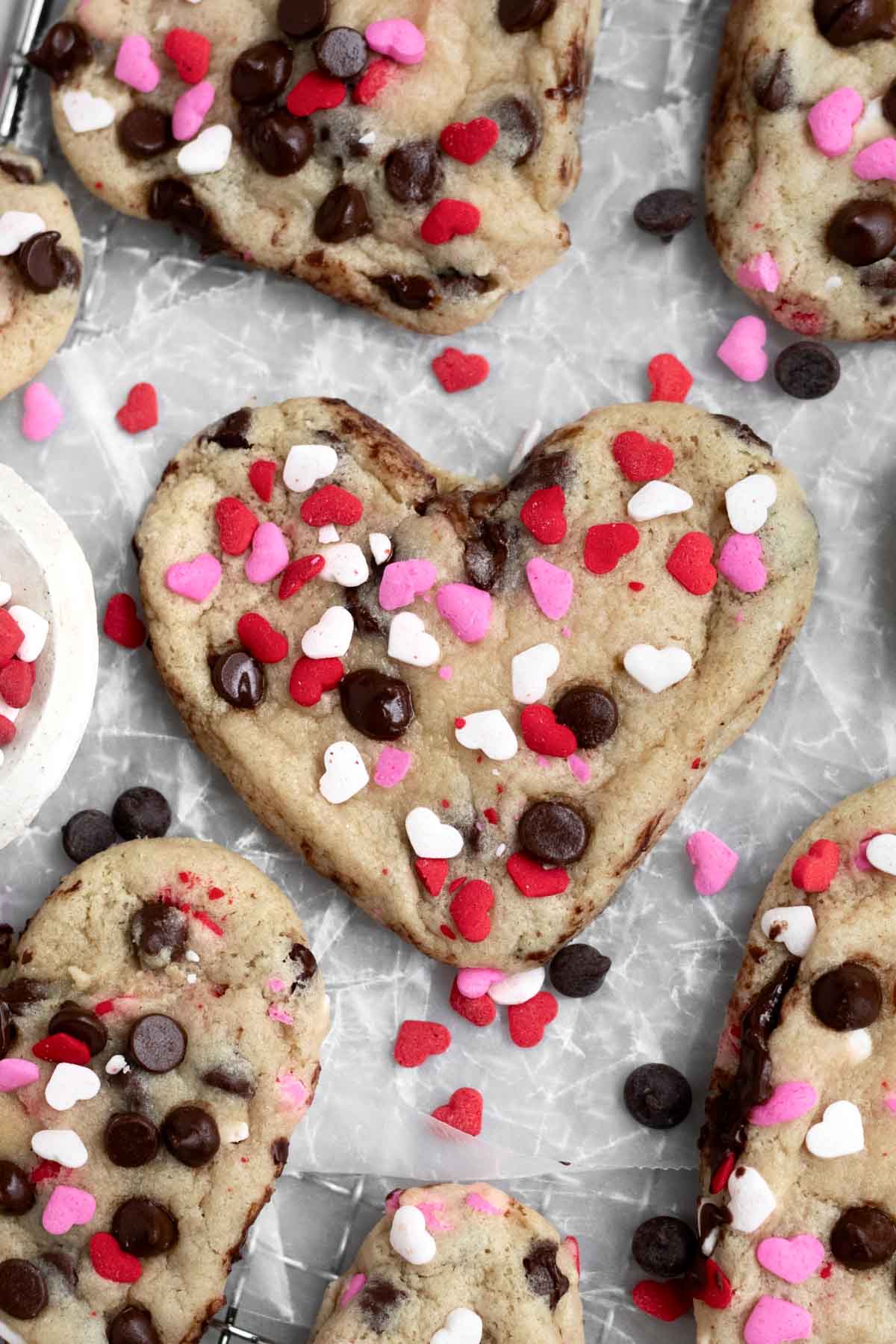 Heart Shaped Chocolate Chip Cookies with gooey chips and sugary pink, red and white heart sprinkles.