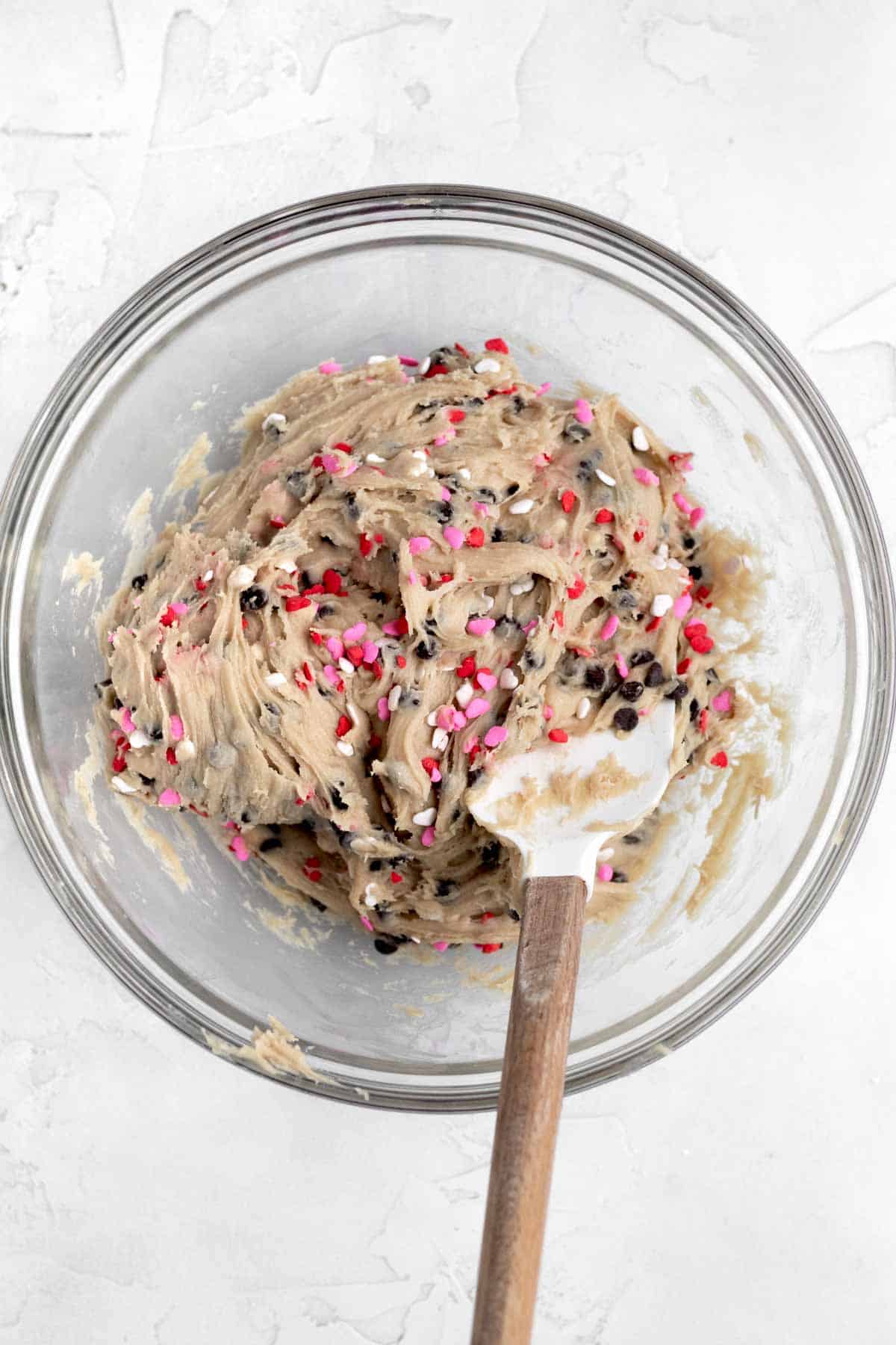 Folding in the pink, red and white sprinkles into the batter.