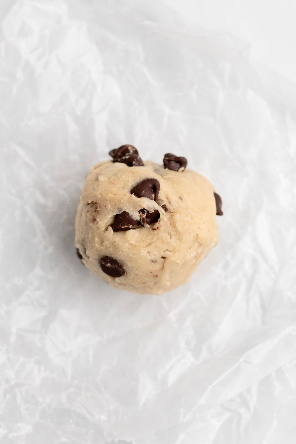 A scooped ball of cookie dough with chocolate chips.