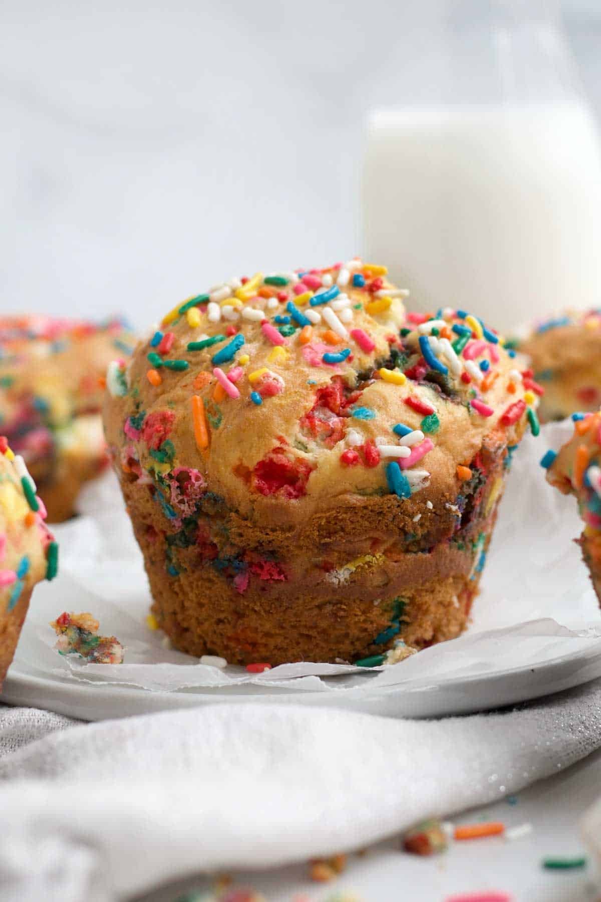 A perfect gluten free, golden brown Birthday Muffin with bright colorful rainbow sprinkles.