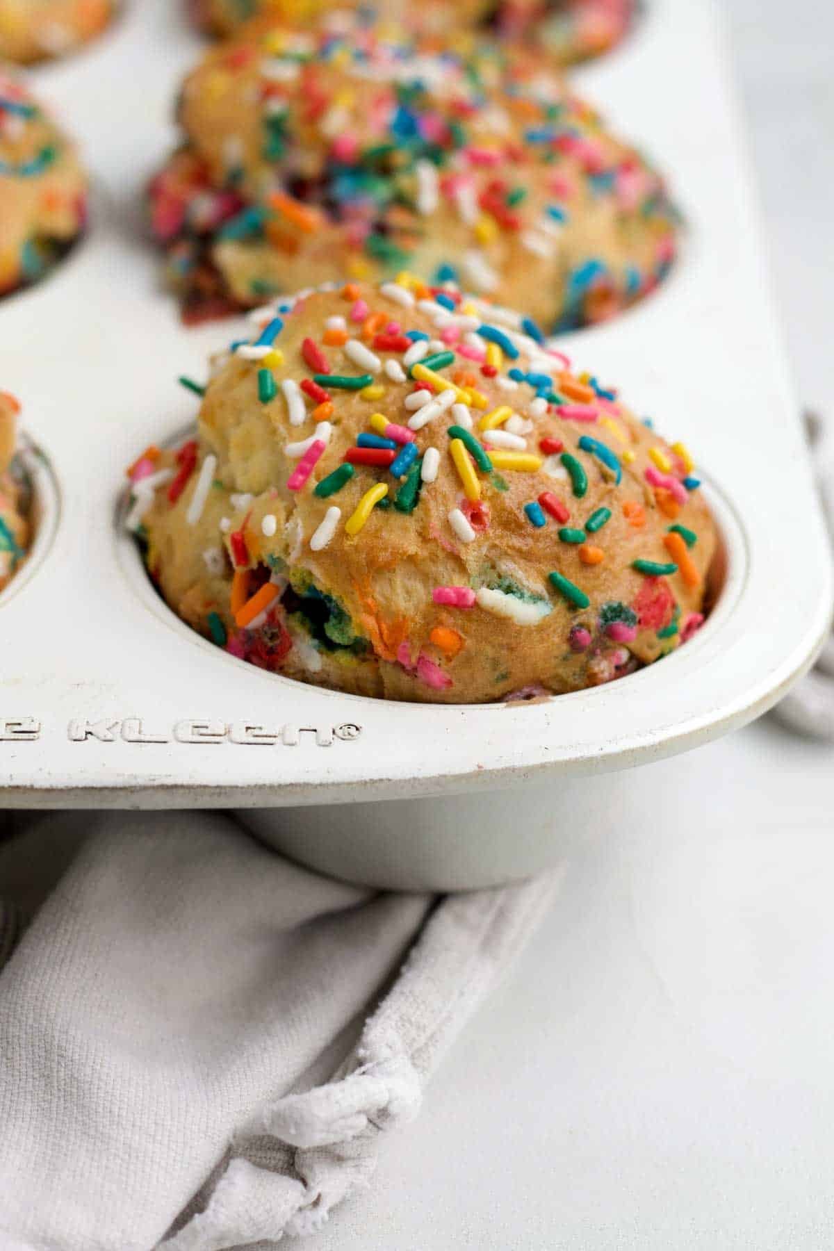 The high golden brown dome of the Birthday Muffins with rainbow sprinkles.