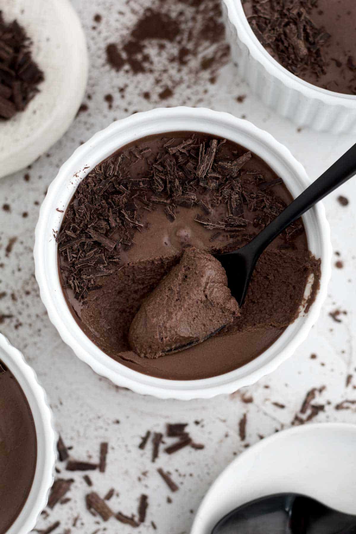 A tasteful bite of Easy Chocolate Mousse in a ramekin with shaved bits of chocolate.