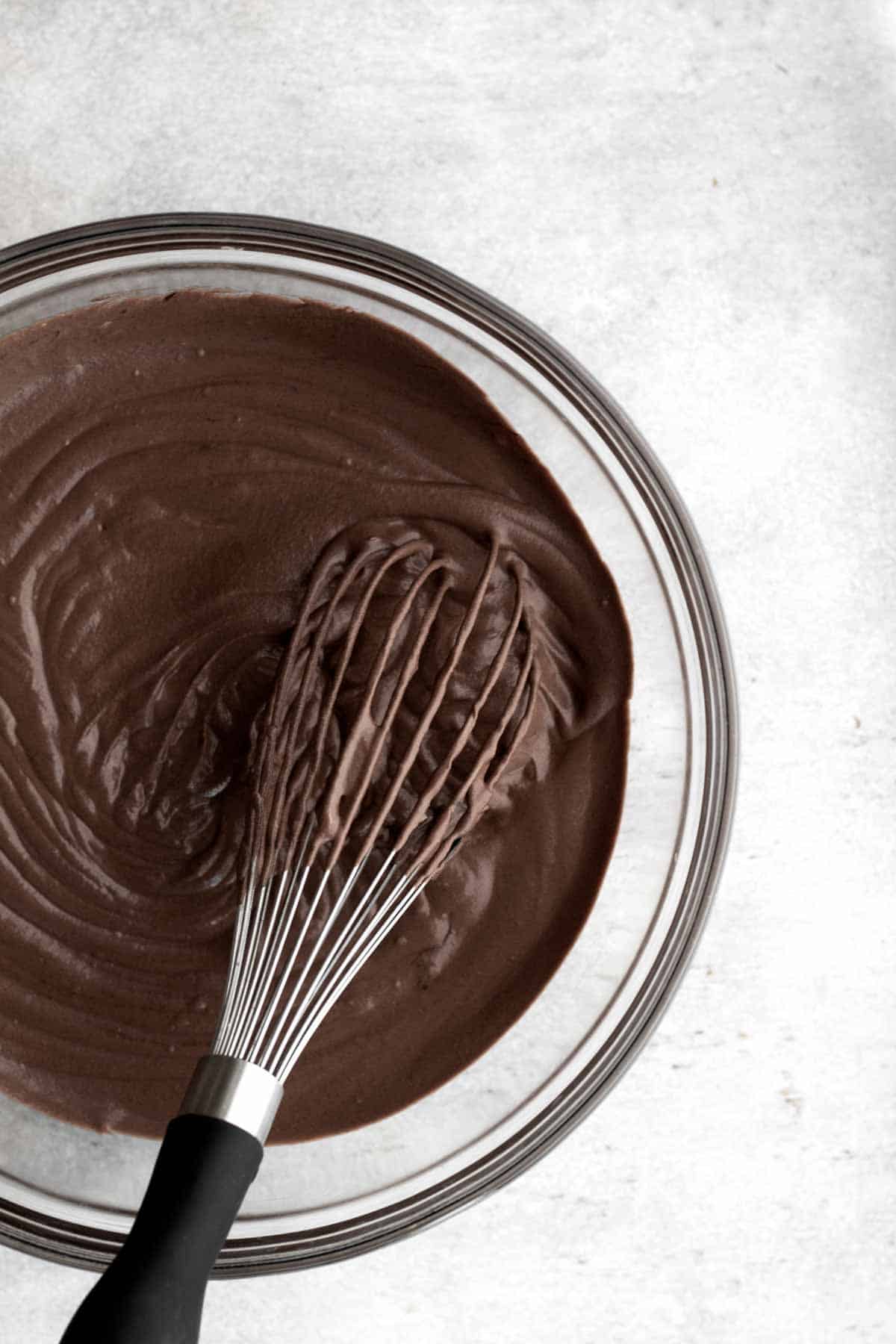 Whisking and mixing the whipped cream into the bowl.