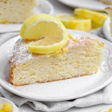 A light and delicious sugary slice of Lemon Tea Cake topped with a slice of lemon.