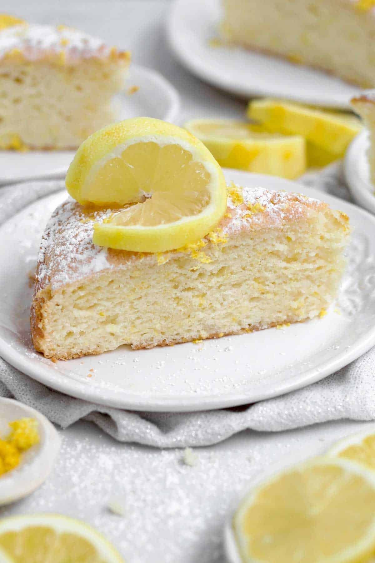 A light and delicious sugary slice of Lemon Tea Cake topped with a slice of lemon.