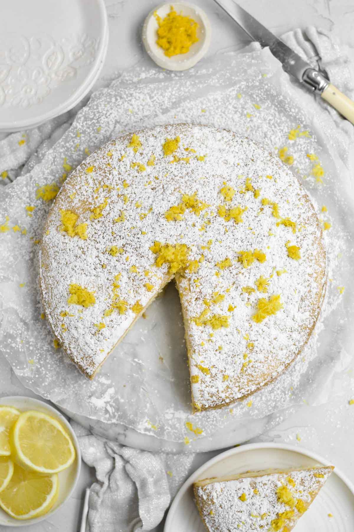 Bright yellow and tangy lemon zest dot the powdered sugar landscape of the Lemon Tea Cake.