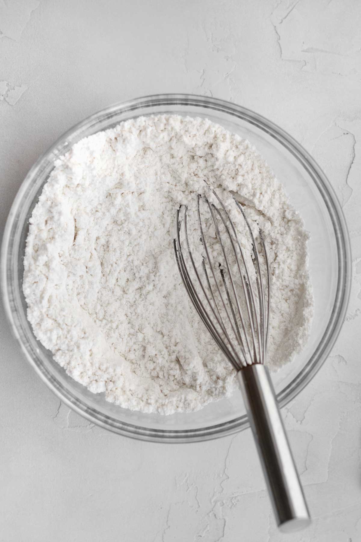 A whisk with the white dry ingredients.