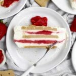 A layered slice of Strawberry Cream Cheese Icebox Cake with bright strawberry sauce filling.