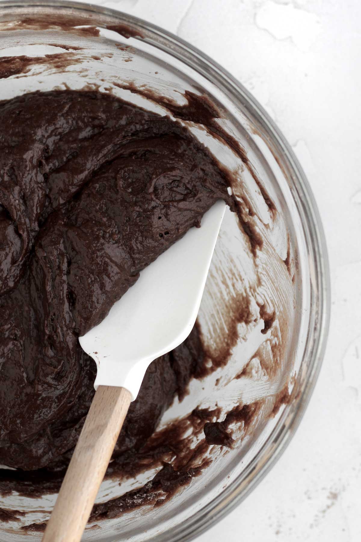 Mixing in the wet ingredients into a rich chocolate cake batter.