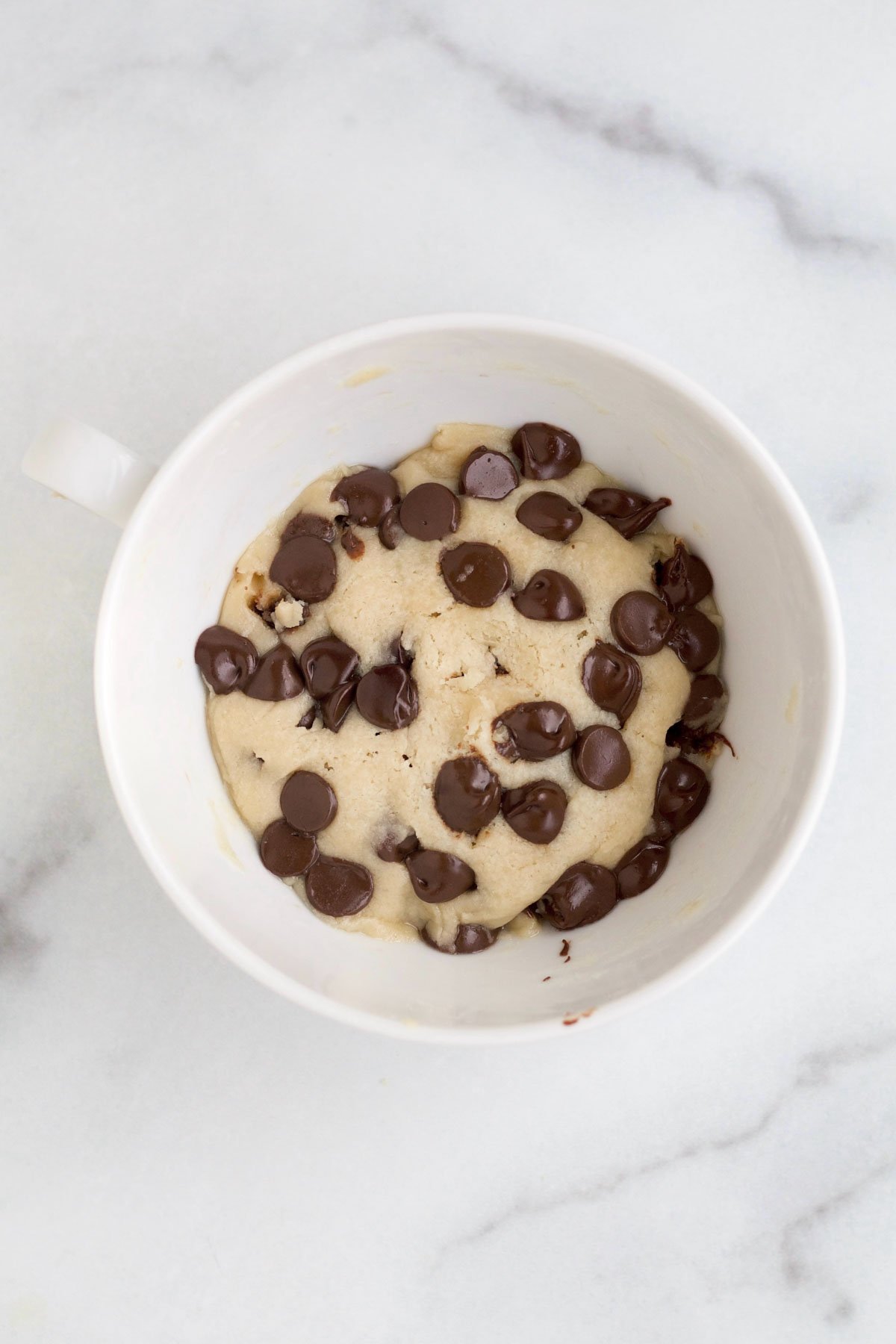 Warm cookie mug cake with slightly melted chocolate chips.