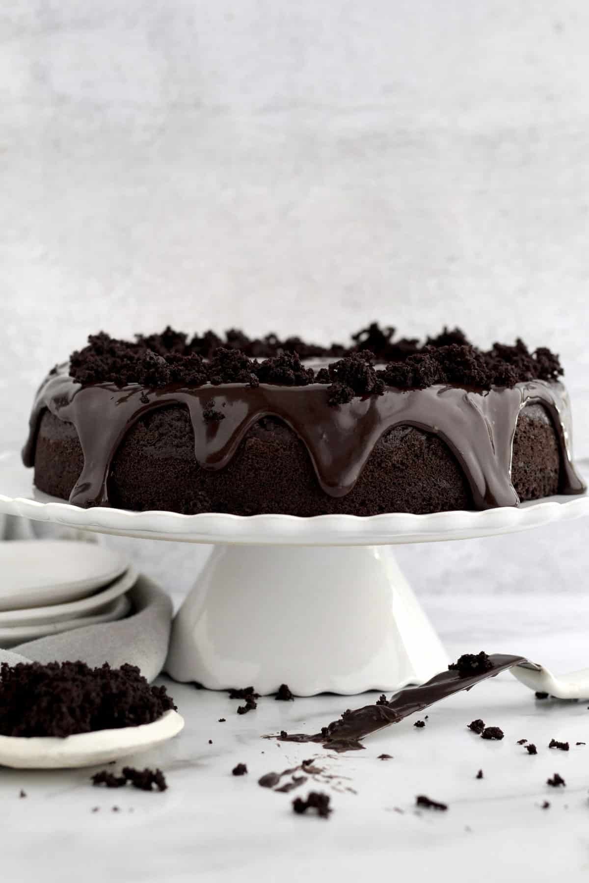 Decadent chocolate cake with glossy chocolate ganache and textured crumbled chocolate cake topping.