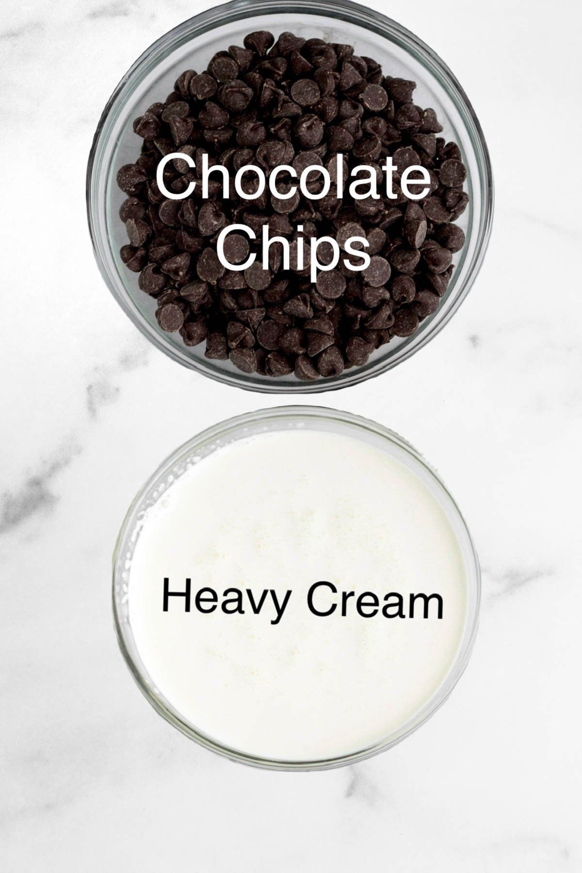 Two bowls of chocolate chips and heavy cream.