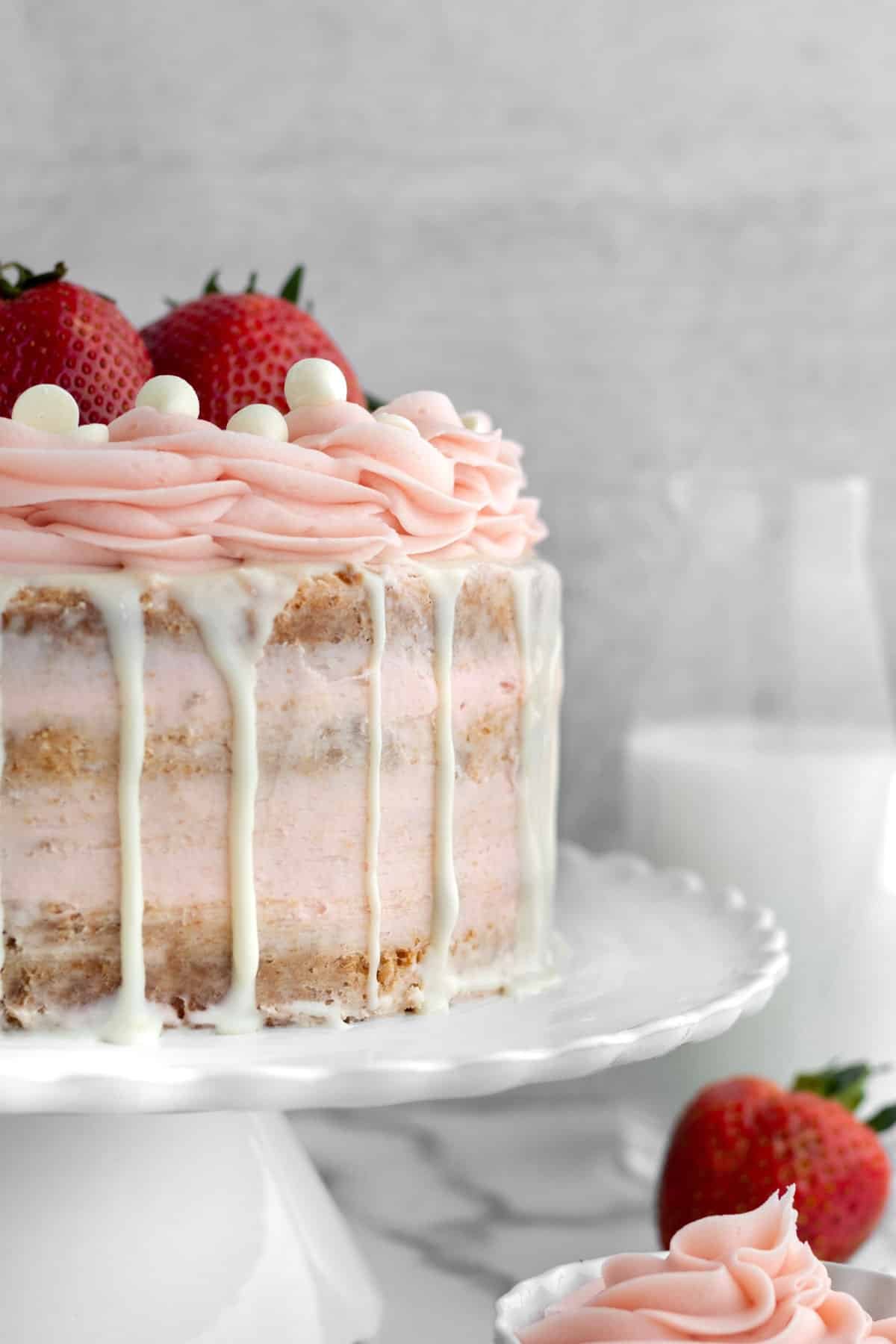 Sugary white chocolate drips down the side of this Strawberry Cake.